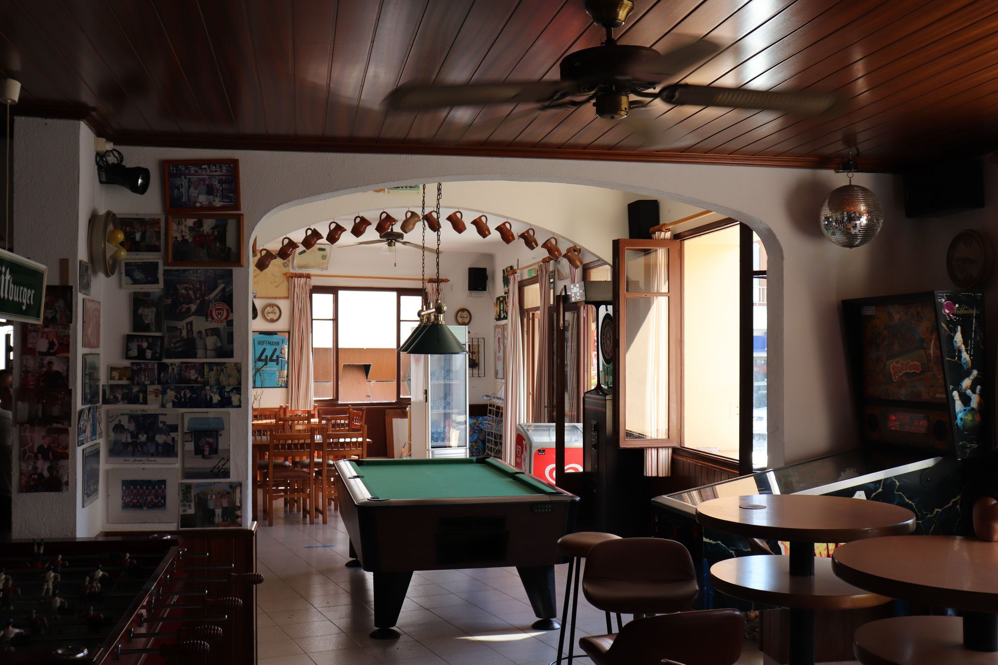 A relaxed common room with a green-baize pool table, wooden chairs and a beamed ceiling